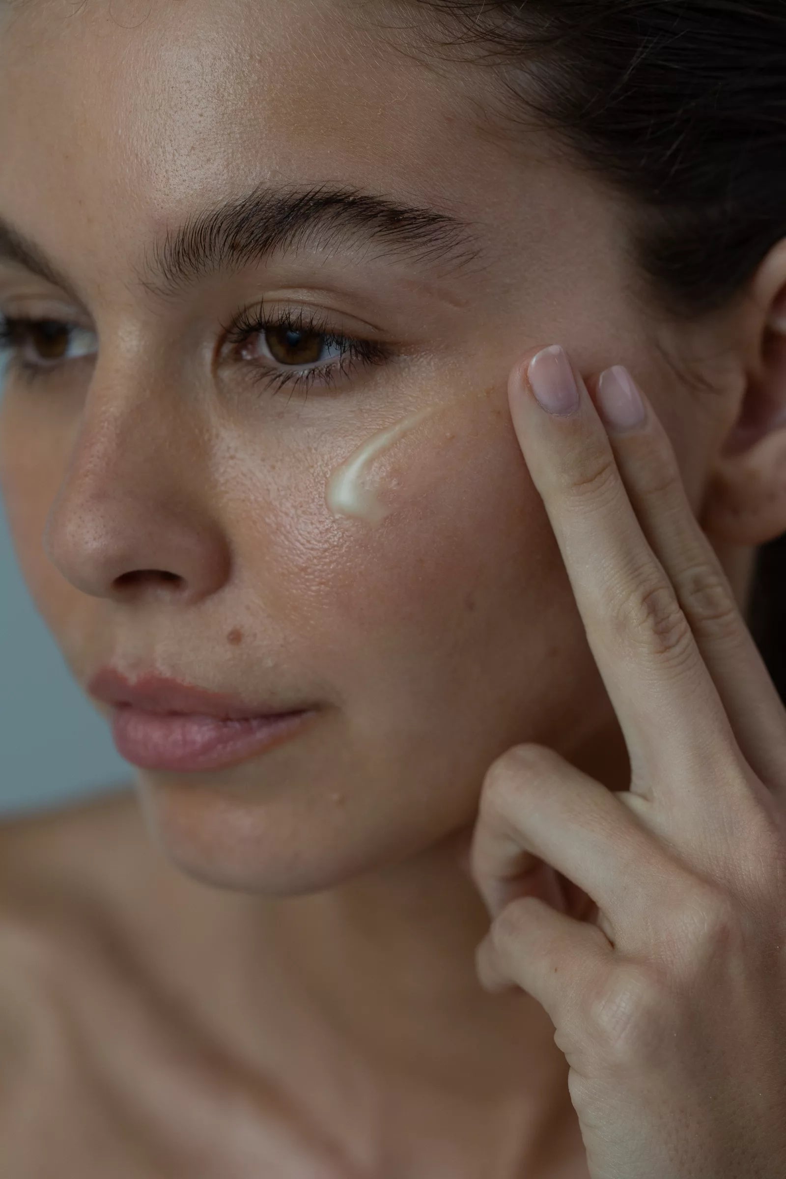 Defy Retinol Serum being applied to the cheek